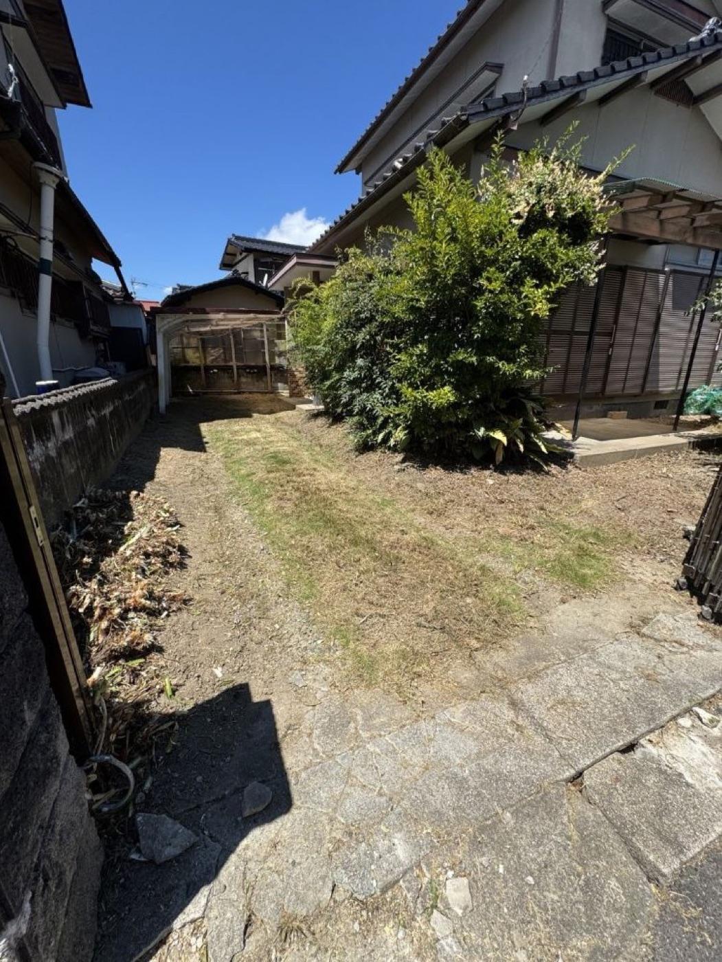 作業後：家の脇の庭。伸び放題の草を刈り、石畳と通路が見えるように